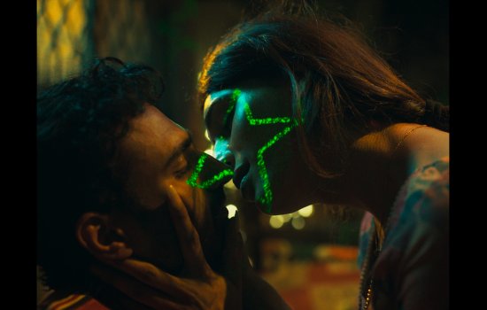 Two people are about to kiss. One has a luminous star shape printed on their face.