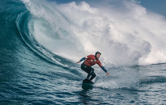 A surfer rides a large wave.