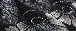 A detail of a beaded black dress from 1929 showing intricate beadwork in an art deco pattern