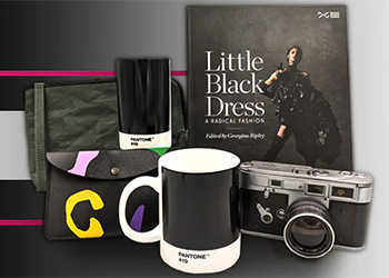 A selection of objects from the online shop, including a black Pantone mug, a black leather purse with colourful shapes, and a copy of the exhibition book.