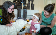 A learning assistant shows a baby a polar bear as part of the magic carpet sessions. 