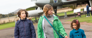 A family of three, a mum and two children, explore the grounds at the National Museum of Flight.