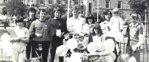 A group of protesters pose together in a black and white photo from the 1960s. 