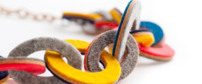 A colourful link necklace, made of circular felt links in dfferent colours including yellow, blue and green.