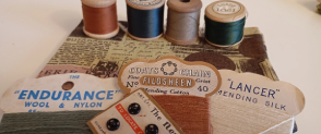 Crafting materials set out on a table, including cotton reels and thread.