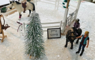 Miniature figurines are displayed in a winter wonderland scene, as part of Clyde's Winter Trail.