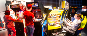 A varied group of visitors are playing games inside Game On at the National Museum of Scotland.