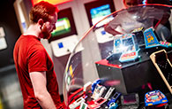 An adult looking at objects on display in the Game On exhibition at the National Museum of Scotland.