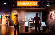 A silhouette of two adults inside the entrance to the Game On exhibition at the National Museum of Scotland.