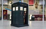 A child looks out of the door of the TARDIS in the Grand Gallery at the National Museum of Scotland