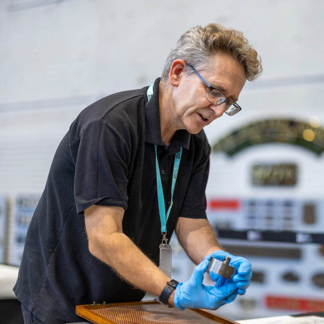 A curator showing off a railway object