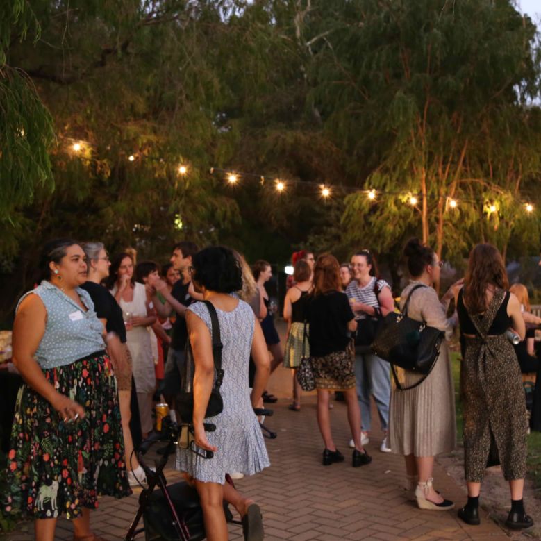 Image: Four people gather together in conversation