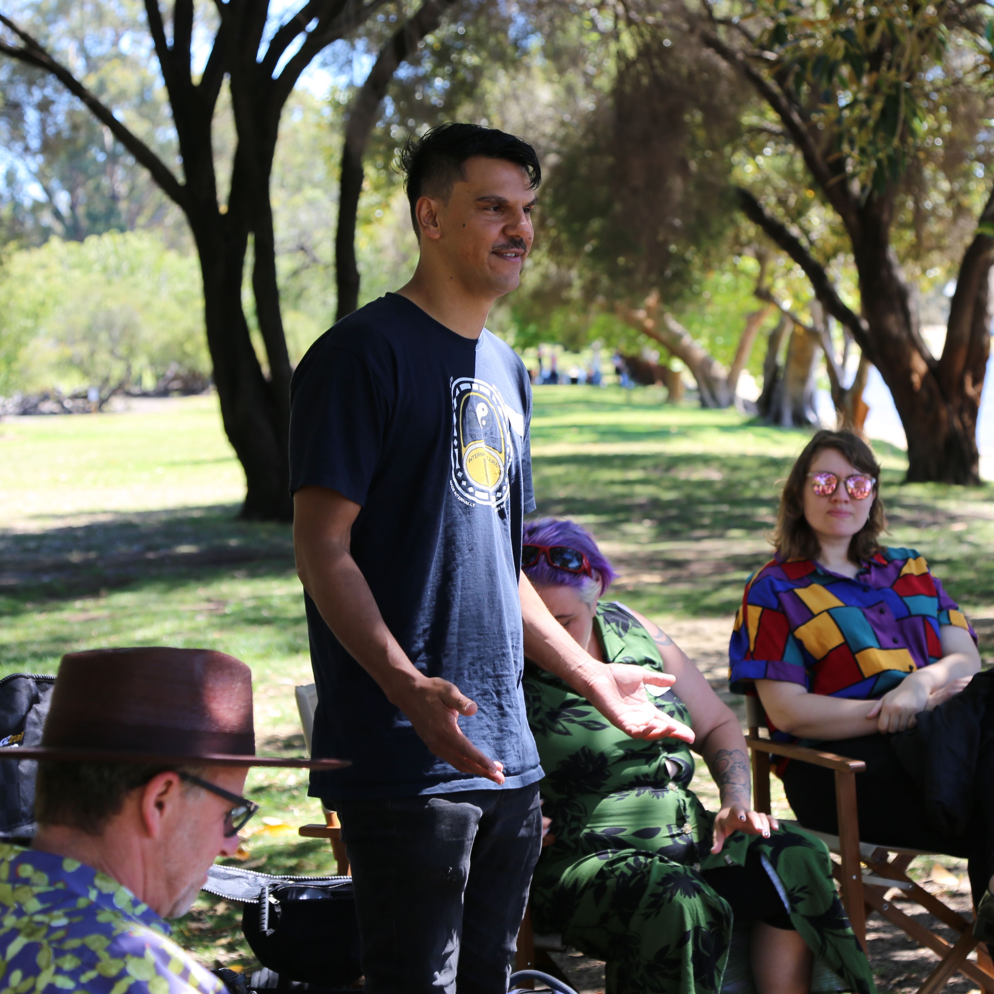 Ian 'Moopa' Wilkes stands talking to a group of people
