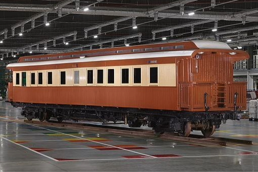 A red railway carriage with yellow trim around the windows. This was a carriage belonging to Rhodesia Railways that was later transported back to the UK for display.