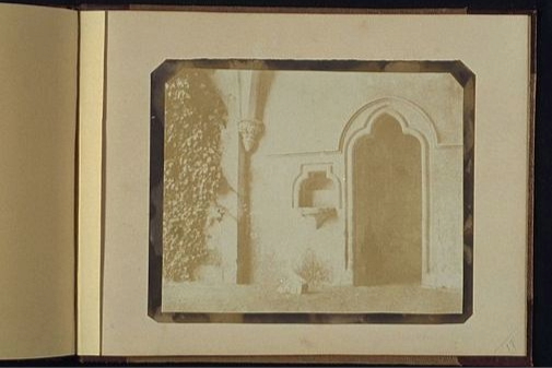 A salt print. Yellow page in photo book, displaying photograph of doorway.