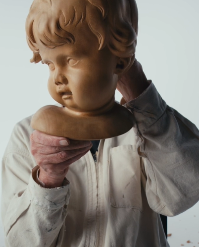 Tony Webb holds up one of his carvings, a cherubic head.