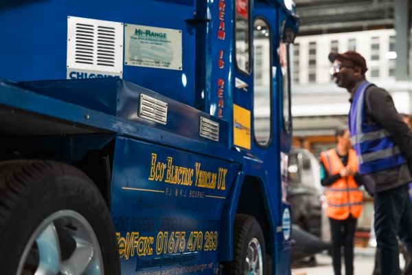 Visitor looking at a blue electric vehicle in the Hawking Building
