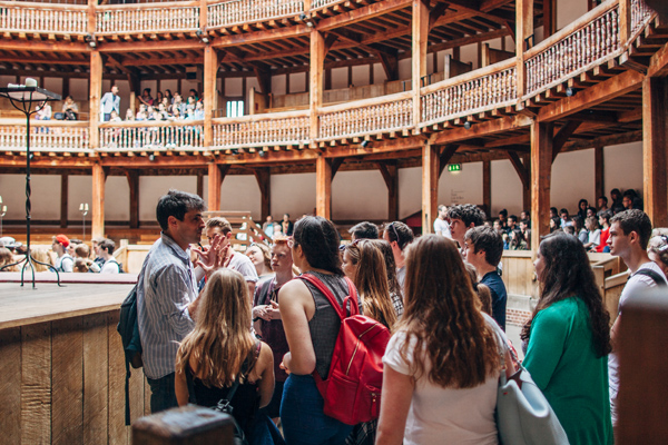 [IMAGE] A school group are taken into the Globe Theatre.