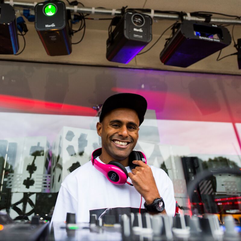 A DJ smiling from behind his deck
