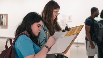 Two students writing on a clipboard at the Hayward Gallery.