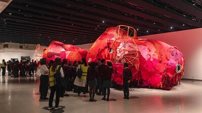 A group of students stood in front of a large red installation