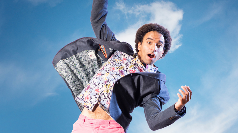 Poet Joseph Coelho in a brightly coloured outfit falling from the sky