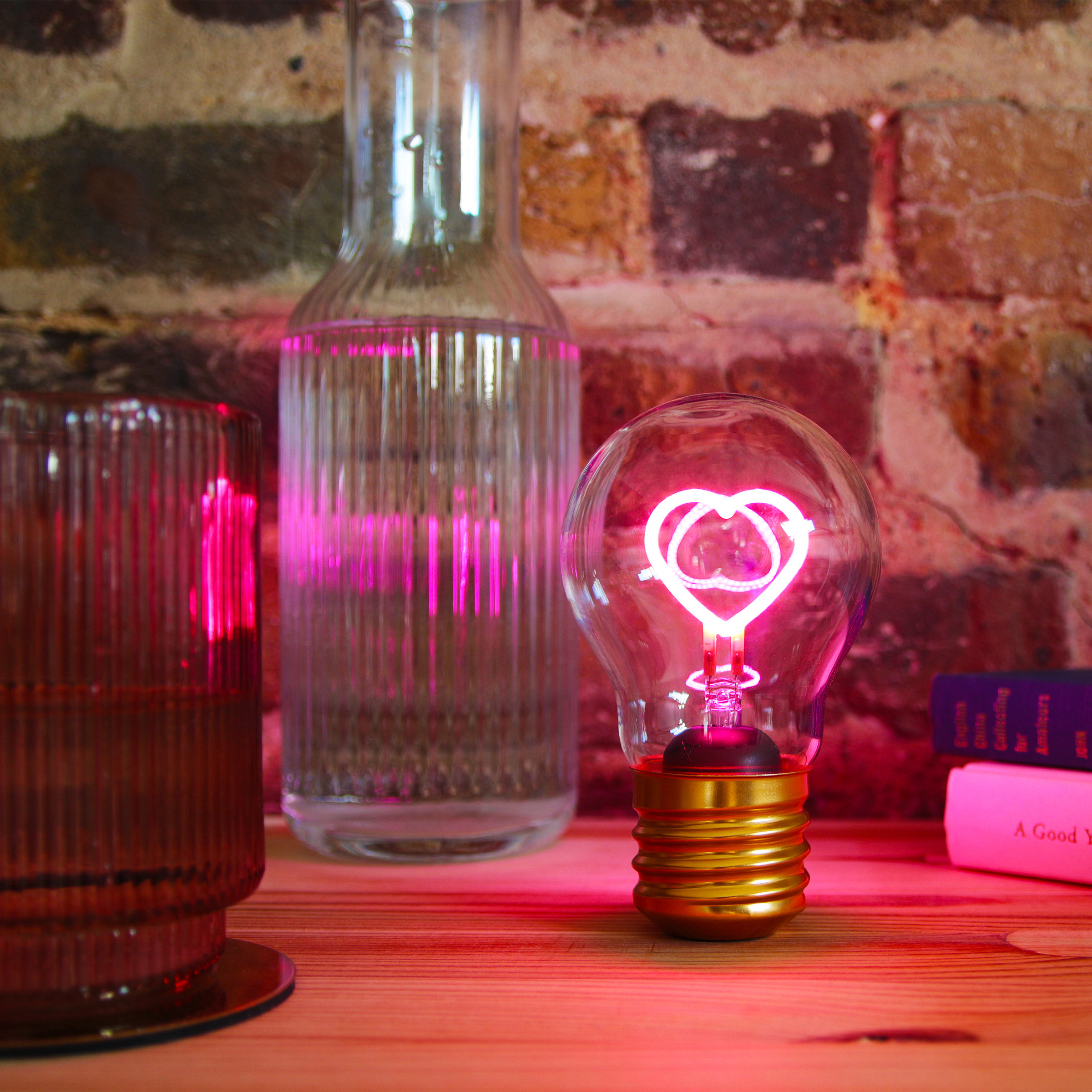 A picture of a cordless lightbulb with a neon heart shape inside