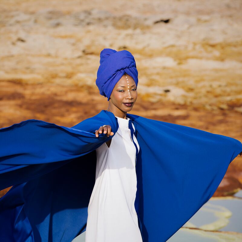 Fatoumata Diawara, Malian singer-songwriter in a blue cape photographed outside