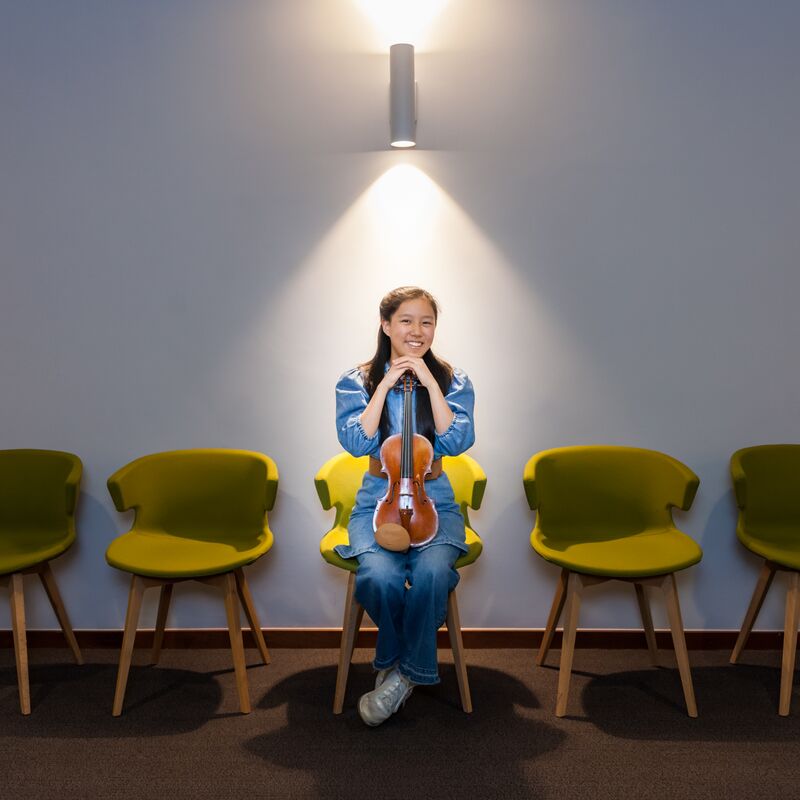 A female violinist under a spotlight