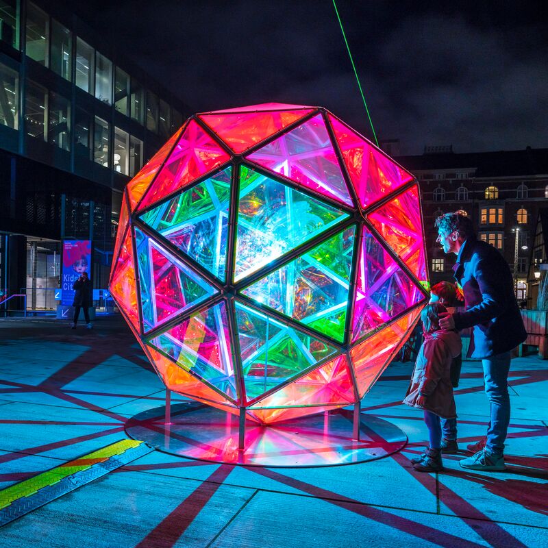A man with his kids watching in Jakob Kvist's Dichroic Sphere