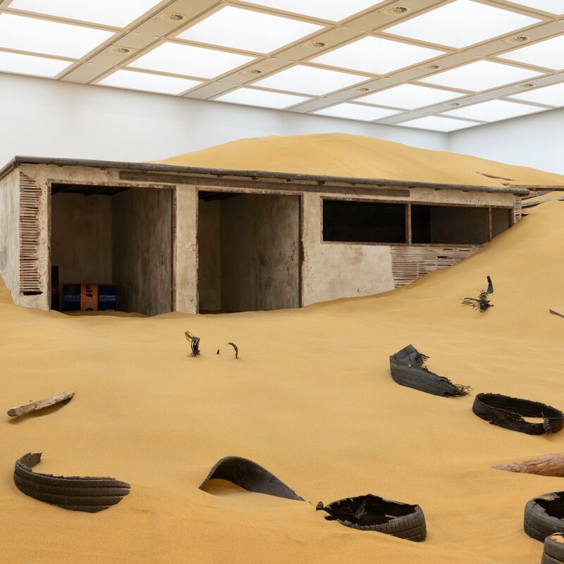 Installation view of Mike Nelson, Triple Bluff Canyon (the woodshed), 2004. Various materials. M25, 2023. Found tyres. Photo: Matt Greenwood. Courtesy the artist and the Hayward Gallery.