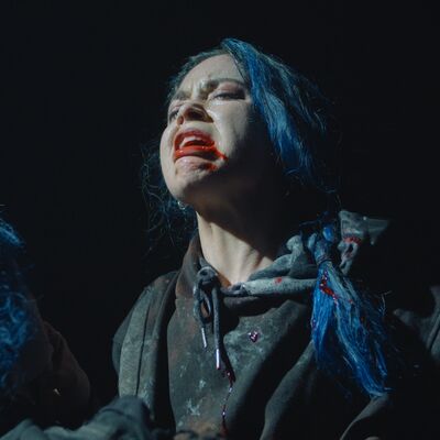 A woman with a bloody mouth and pale make-up