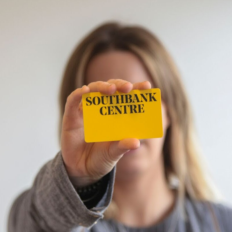 A woman with blonde hair holding a yellow Southbank Centre membership card.
