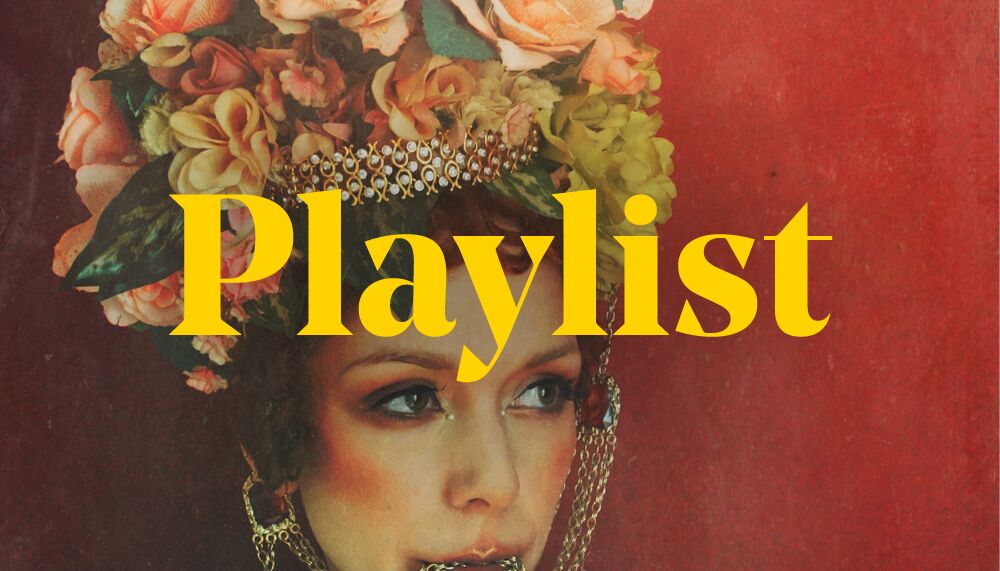 An image of The Anchoress in which she is wearing an elaborate floral headress. The word 'Playlist' overlay the image in yellow