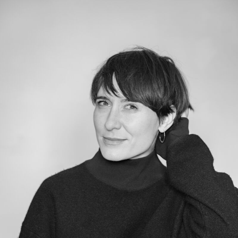 A woman with short brown hair wearing a black jumper