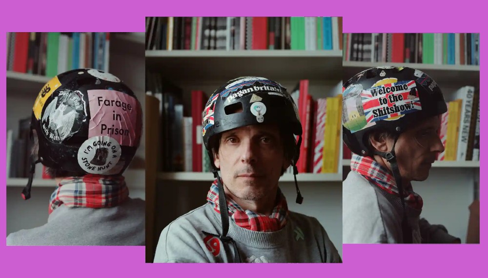 3 images of Jeremy Deller wearing a helmet covered in political colourful stickers,