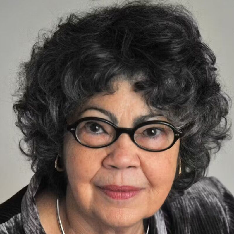 Olive Senior, woman in glasses and short curly hair 