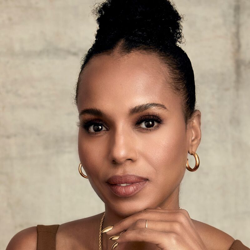 Kerry Washington resting her chin on her hand, wearing gold jewellery and her hair in a bun.