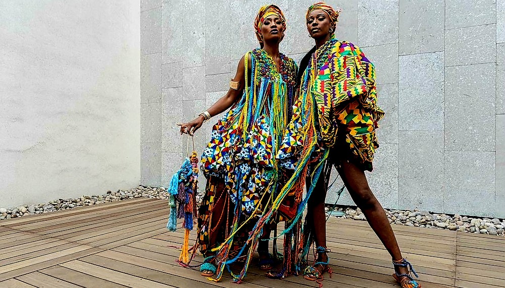 Two women wearing multicoloured dresses