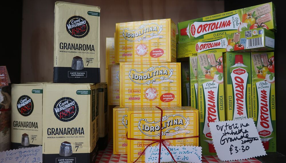 Italian food items stocked on shelves including olive oil, tomato puree, and risotto rice