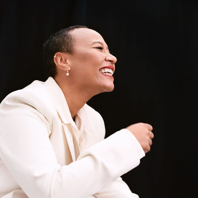 A woman wearing a white suit smiling
