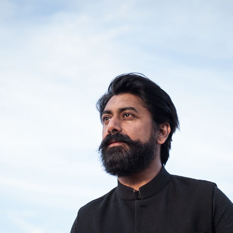 Talving Singh, a man wearing a black jacket looking off into the distance