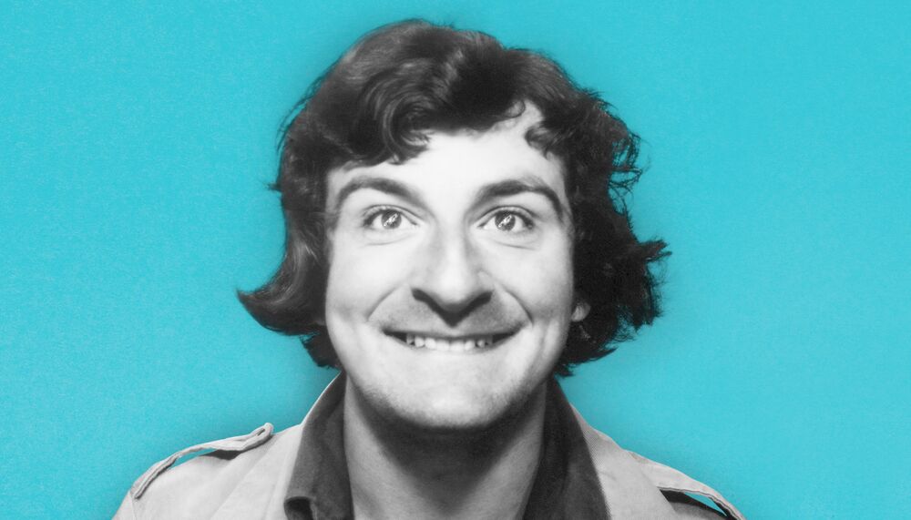 Writer Douglas Adams smiling against a blue background