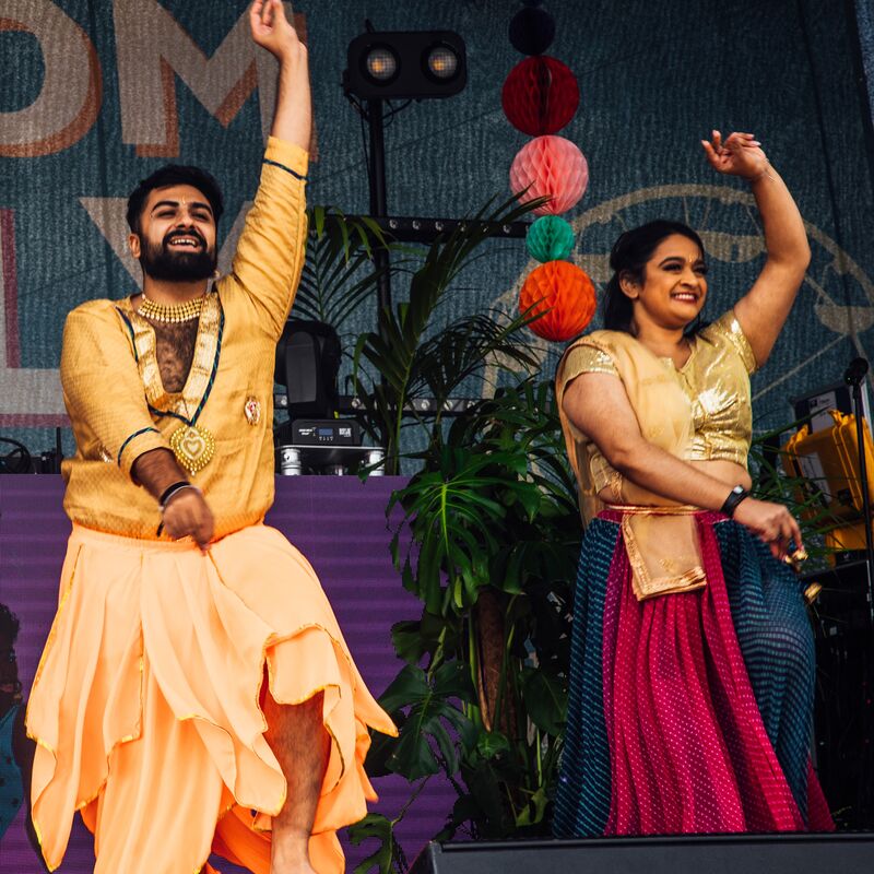 Two South Asian dancers perform on stage
