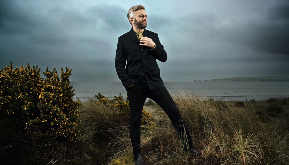 Kirill Karabits standing in the countryside and ocean