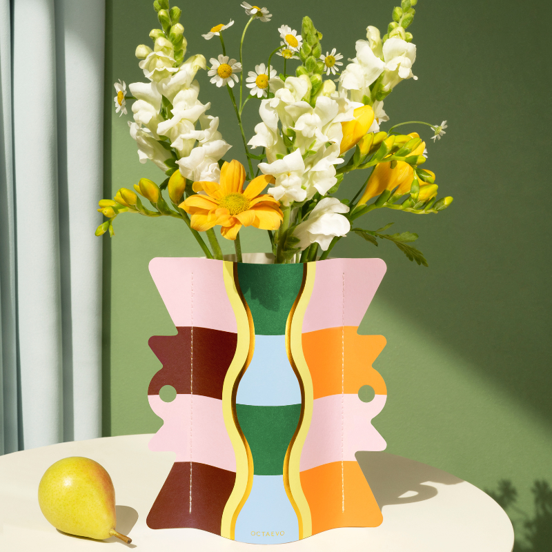 A vase in a colourful geometric pannern with spring flowers
