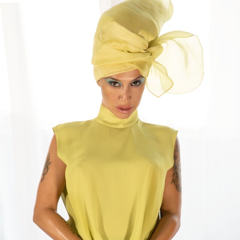 Lady Blackbird wearing a yellow dress and yellow head wrap.