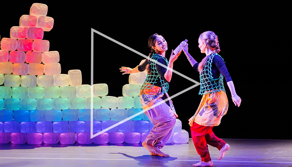Two women wearing Indian clothing dancing in sync