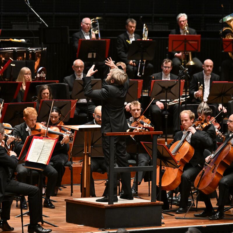 Conductor Kirill Karabits standing in front of an orchestra