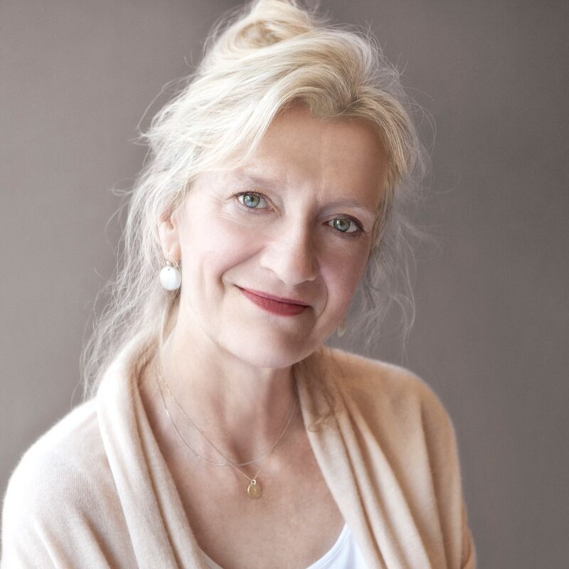 Writer Elizabeth Strout wears a beige cardigan in front of a grey background